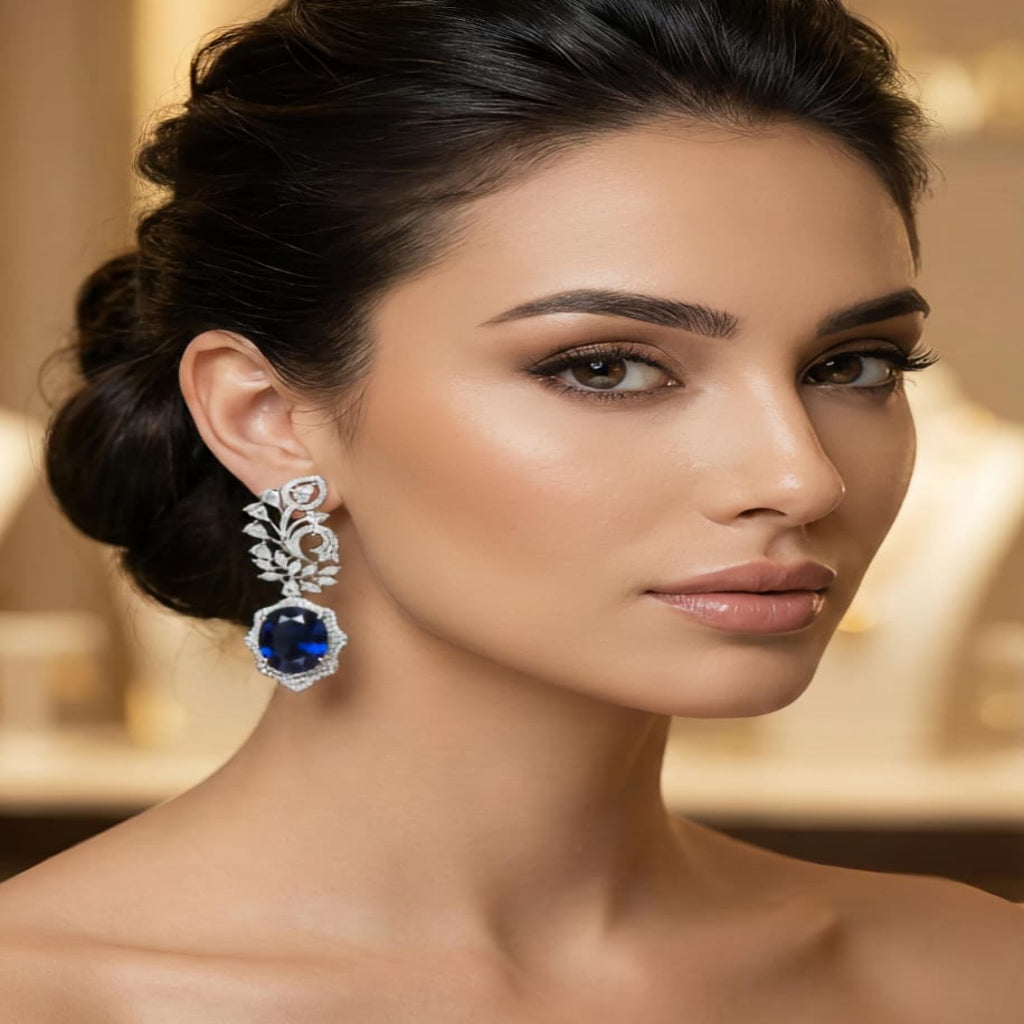 Woman wearing blue sapphire diamond drop earrings in silver setting