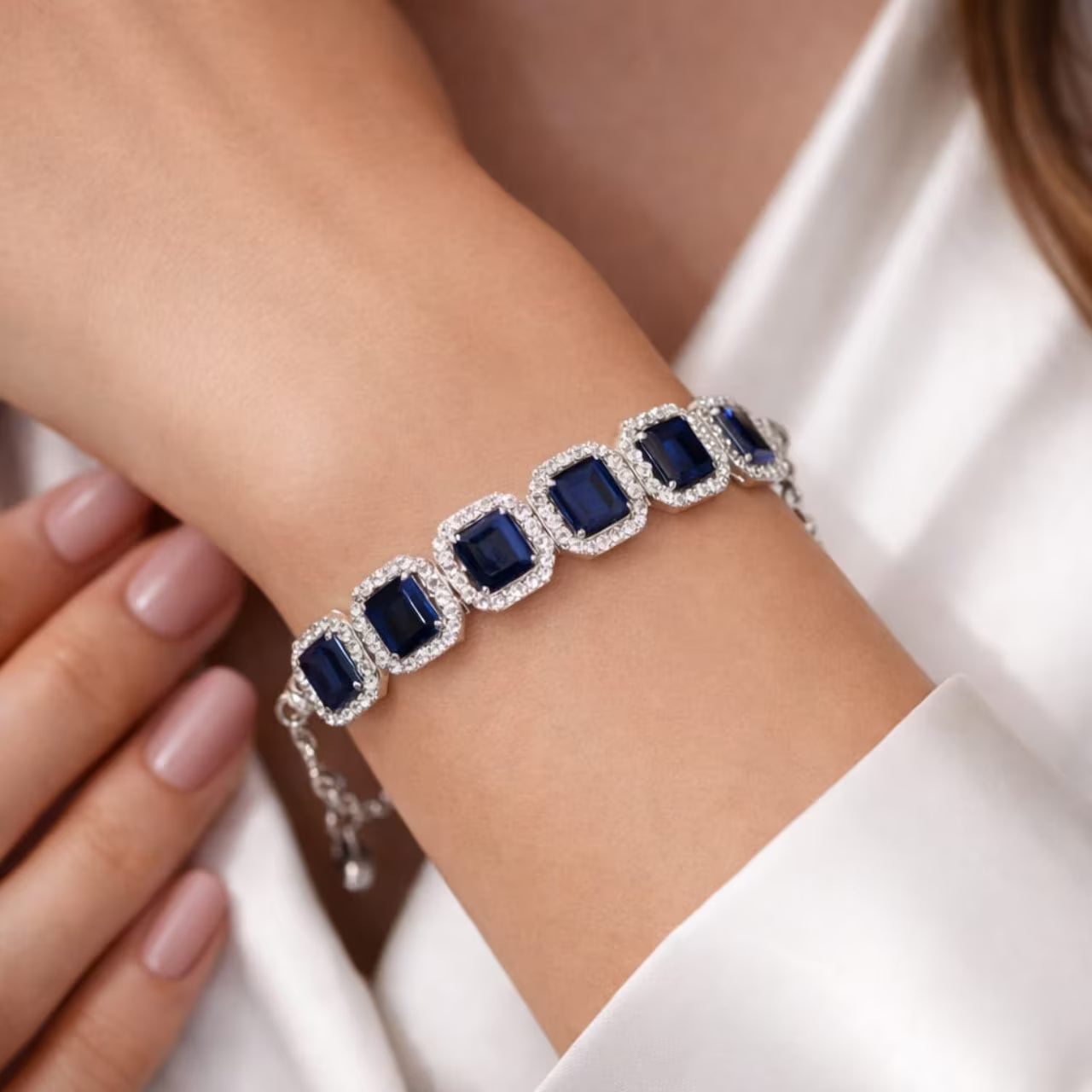 Blue stone diamond bracelet for women with silver finish worn on hand close-up