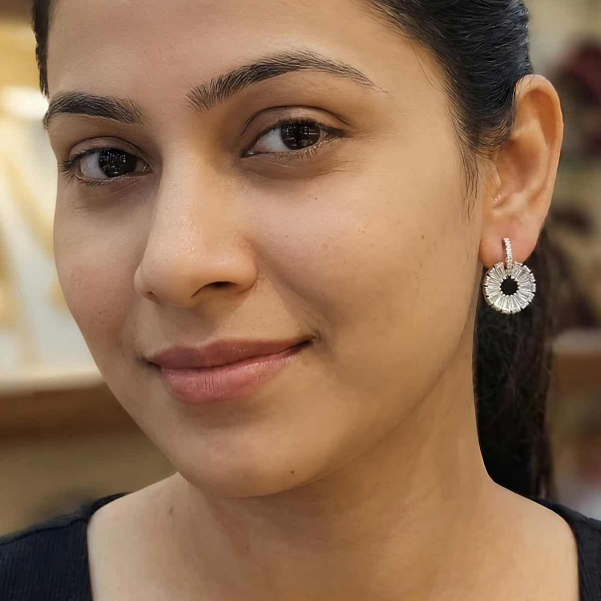Silver diamond floral drop earrings worn by a woman, elegant sterling silver jewellery