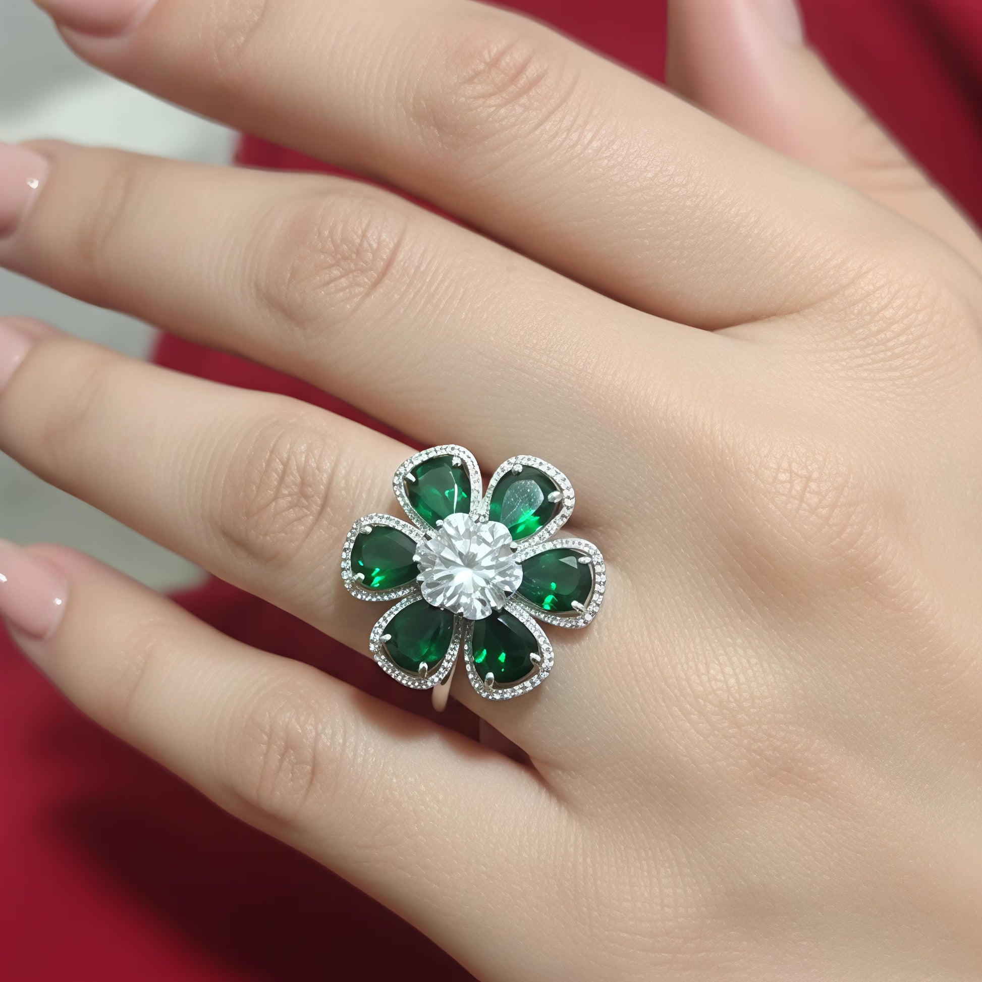 Silver floral statement ring with emerald green stones and white zircon center