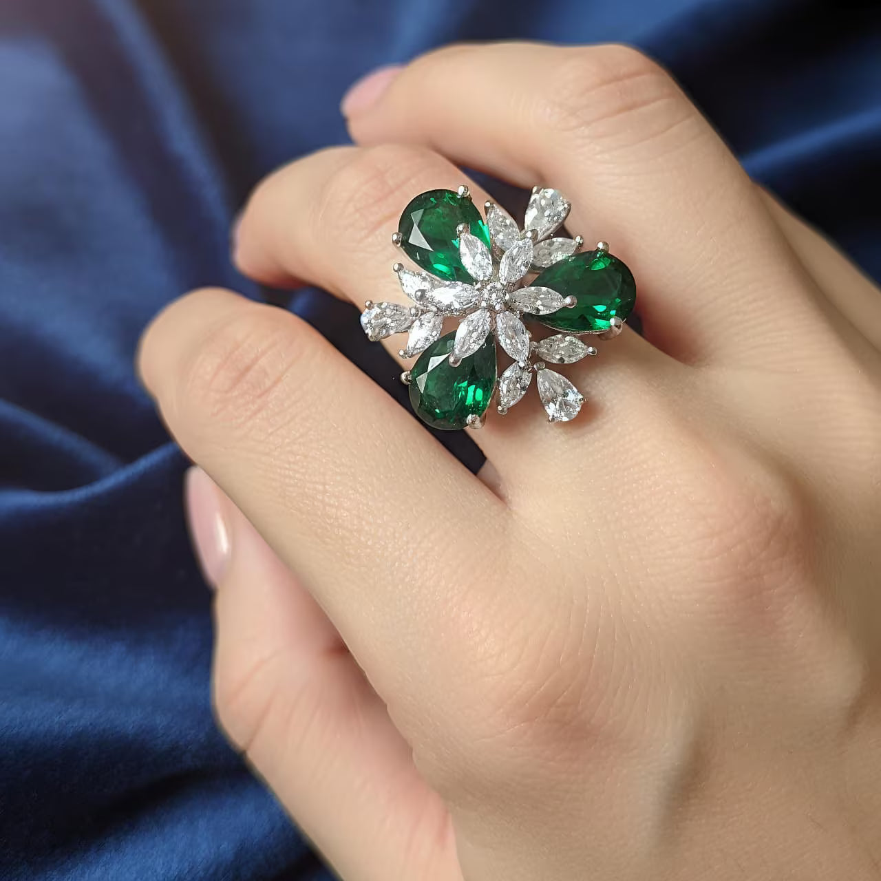
Silver floral statement ring with emerald green stones and white zircon center