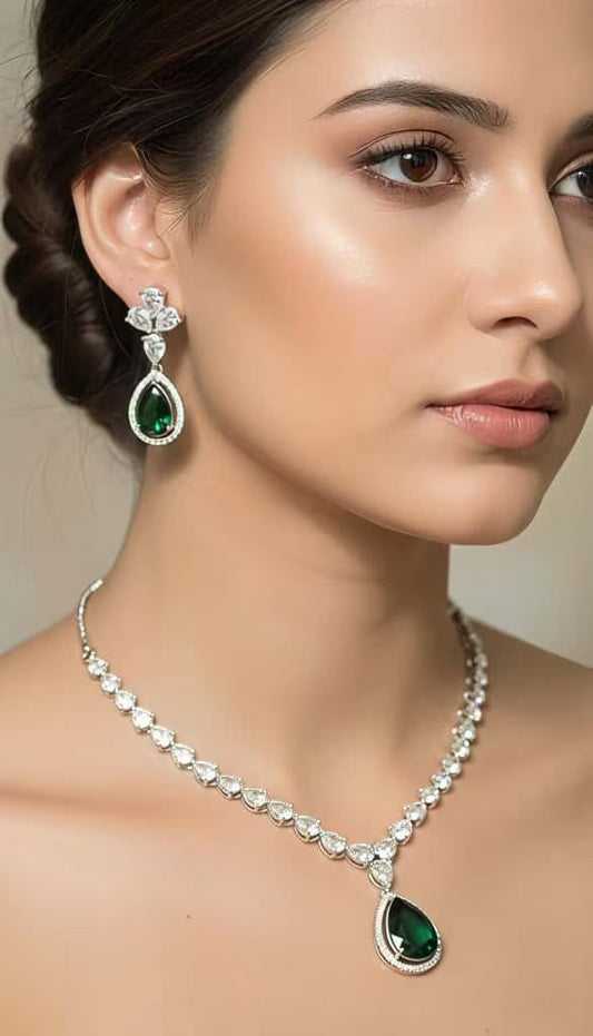 Green teardrop zircon necklace set with leaf design in silver finish by Karat India