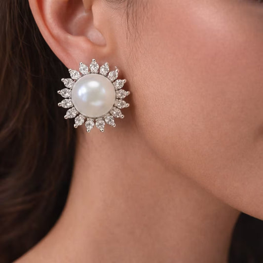 Pearl stud earrings with diamond halo design in silver finish worn on ear