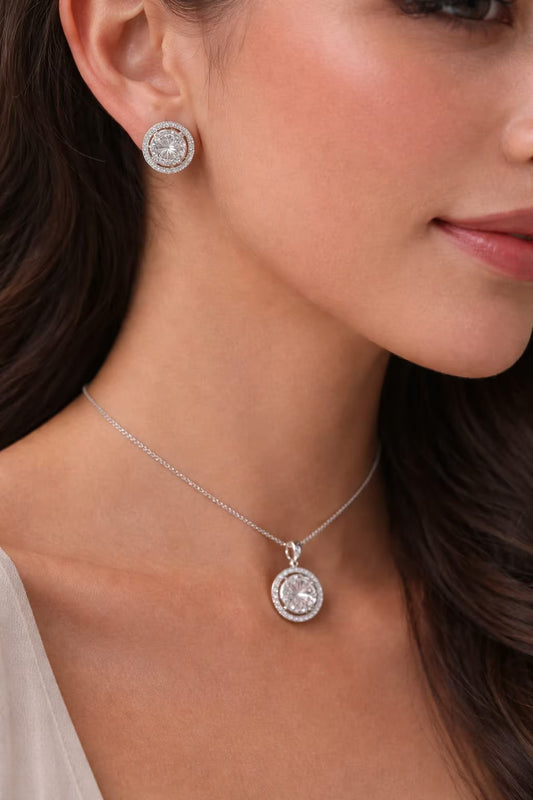 Round diamond look silver pendant set with matching earrings worn by a woman